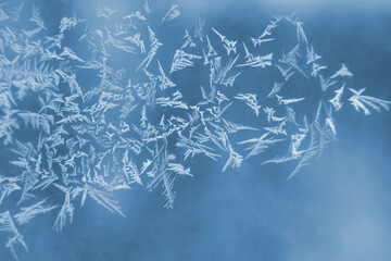 frosty patterns on the window glass closeup. natural textures and backgrounds. ice patterns on...