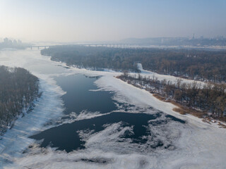 Melting Dnieper River in spring Kiev. Ice crack on the river. Aerial drone view. Spring sunny morning.