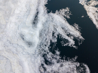 Ice melts on the river. Ice crack. Aerial drone view. Spring sunny morning.