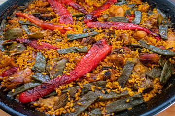 Close-up of a traditional Valencian Paella, cooked in a paella pan, with natural ingredients and homemade elaboration.