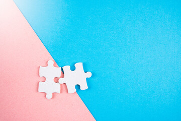 Puzzle pieces on pink and blue background.