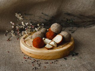Exquisite rare Italian cheese variety Berel Knoll on a wooden round tray on a background of...