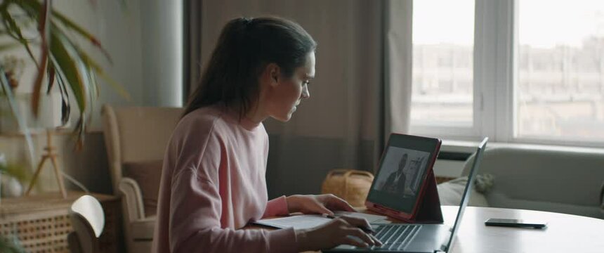 DOLLY IN Mid 30s Caucasian female working from home, having a video call with client or colleague. WFH, stay home, COVID-19 coronavirus pandemic new normal concept