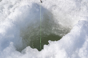 A hole in the frozen lake close-up.winter fishing