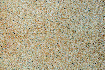 Finely structured sand-colored surface with black dots