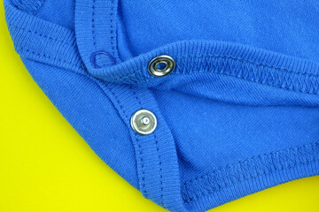 Close-up of cotton fabric with rivets. Accessories for children's clothing. Buttons for baby bodysuit. Clothing for babies.