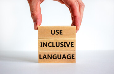 Use inclusive language symbol. Wooden blocks with words 'Use inclusive language'. Beautiful white background, businessman hand. Business and use inclusive language concept. Copy space.