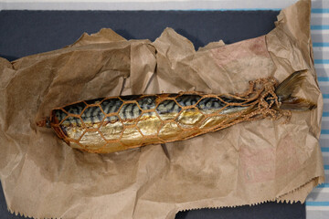 Smoked mackerel in a grid on paper top view. Headless mackerel carcass, smoked fish.