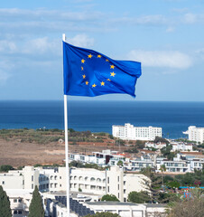 European Union flag on background of resort town and sea in Republic of Cyprus