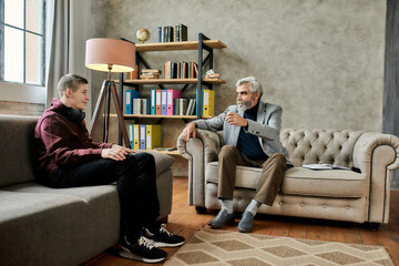 Smiling teenage boy listening to psychotherapist in office