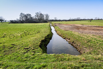 Irrigation water channel in a rural landscape. Upper Rhine Valley, Baden Wuerttemberg, Germany