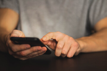 A man holds a smartphone in his hands. Close-up