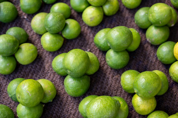 green lemons arranged for sale in the market