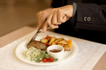 man eating lulakebab with potatoes in a restaurant