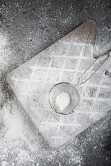 Fresh wheat floor spilled on wooden board on black surface