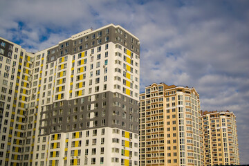 Fototapeta na wymiar facade of apartment buildings. buildings stretch towards the sky. the sky with gray clouds hang over high-rise buildings. matrix of windows
