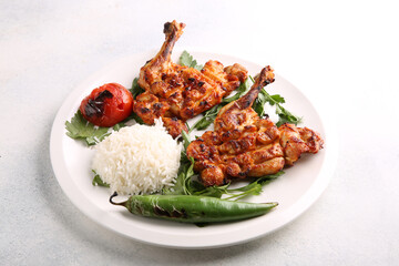 Turkish cuisine. Tobacco chicken with rice, chili pepper, herbs and tomatoes on a white plate on a white table. Restaurant menu, background image, horizontal. Fried chicken