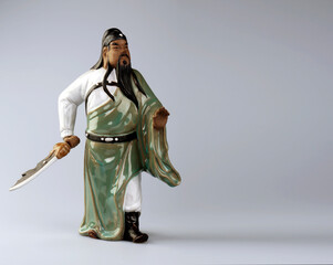 A porcelain figurine of a Chinese warrior holding a sword