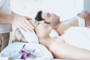 Obraz na płótnie Canvas young beautiful woman in spa salon. Attractive woman enjoying a head massage.