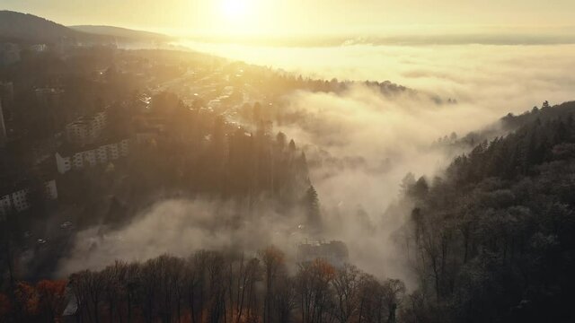 Glorious aerial scenery of fog and gold sunrays beautifully moving and creating a magical mood 