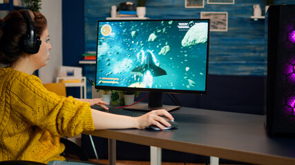 Professional esport woman gamer compete in a video game playing on a championship event. Online streaming cyber performing on powerful personal computer in stylish room during gaming tournament © DC Studio