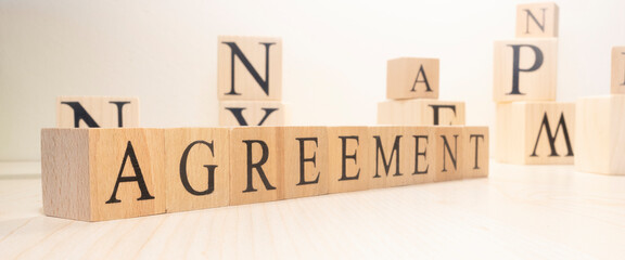 The word agreement is made of wooden cubes. Background from wooden letters.