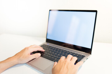 Fototapeta na wymiar hands typing on laptop on a white table.