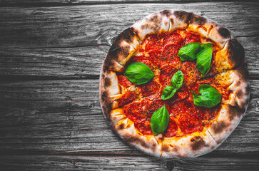 Pepperoni Pizza with Mozzarella cheese, salami, Tomato sauce, pepper, Spices and Fresh basil. Italian pizza on wooden table background