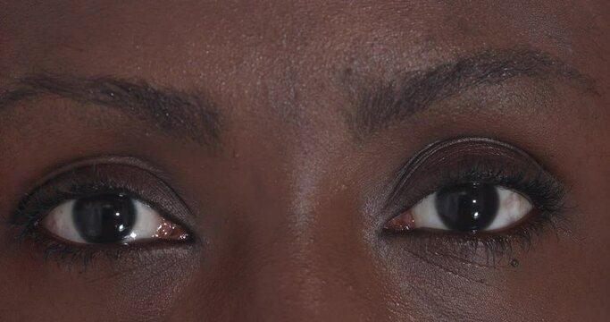 beautiful black woman eyes open and stare at the camera - macro