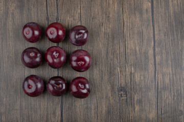 Set of healthy fresh purple plums on wooden table