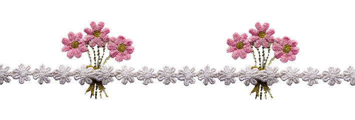 Braid, ribbon, lace from white embroidered flowers. In the middle are bouquets of pink flowers. Isolated on white background.