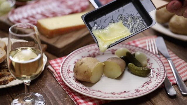 melting raclette cheese with freshly boiled potatoes, swiss food