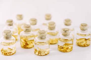 Flasks with gold samples on a white background. Copy, empty space for text