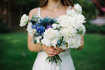 Beautiful modern wedding bouquet in the hands of the bride.