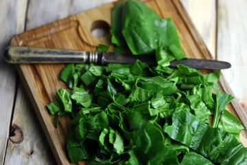Selective focus. Sliced fresh spinach on a board. Green juicy spinach. Cooking spinach.