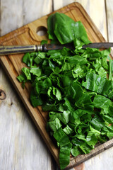 Selective focus. Sliced fresh spinach on a board. Green juicy spinach. Cooking spinach.
