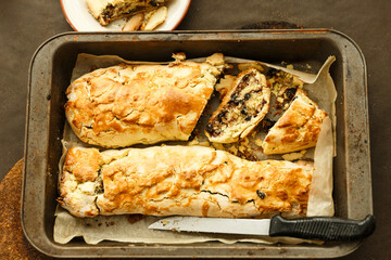 Two rolls with raisin and nuts on the pan and baking paper