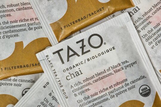 Houston, Texas USA 02-25-2021: Unopened Tazo chai flavor tea bag square packets scattered loosely, macro image. The company was founded in 1994.