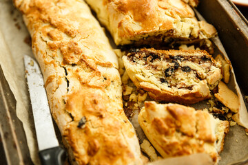 Two rolls with raisin and nuts on the pan and baking paper