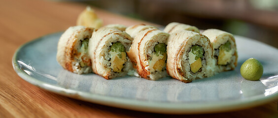 Closeup shot of sushi rolls served on plate in a restaurant
