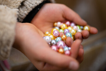 沢山のビーズを持った子供の手