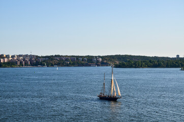 Beautiful yacht sailing through the calm, blue waters of the Baltic Sea along the shores of...