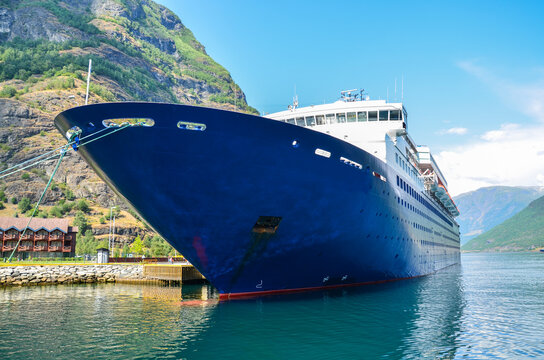 Huge Cruise ship in sea port of Flam. Beautiful landscape with fjords on background. Sognefjord, Norway. Cruise destination and travel.