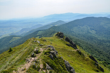 Beautiful summer landscape with forested hills in the distance, and clouds in the sky above the valley. Carpathian mountains, Ukraine