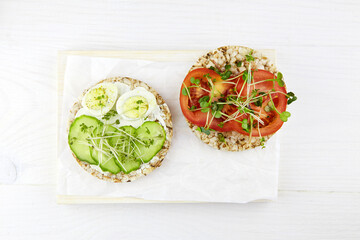 Toasts with egg, micro greens, cucumbers and tomatoes. Healthy breakfast , plant based food. Flat lay, top view.