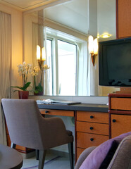 Living room of balcony suite cabin stateroom in clean modern cozy interior design with desk, arm...