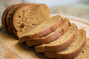 Bakery - golden rustic crusts of bread and buns on a black chalkboard background. Still life captured from above (top view, flat lay). Layout with free copy (text) space.