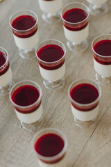 Delicious italian dessert panna cotta with berry sauce on gray background.