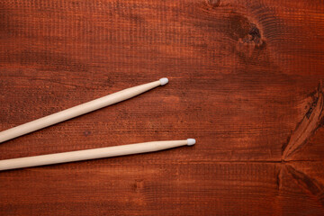Two drumsticks on the dark wooden table