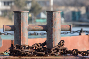 A mooring post and a rusty chain on the pier.